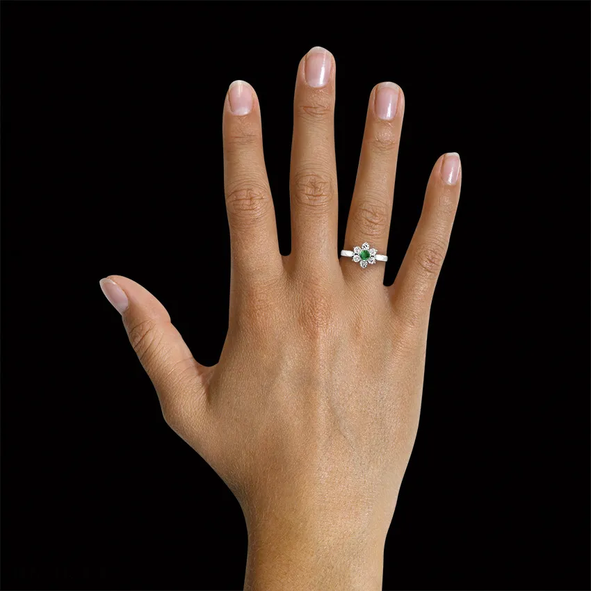 Anillo flor en Platino con esmeralda redonda y diamantes en los lados 