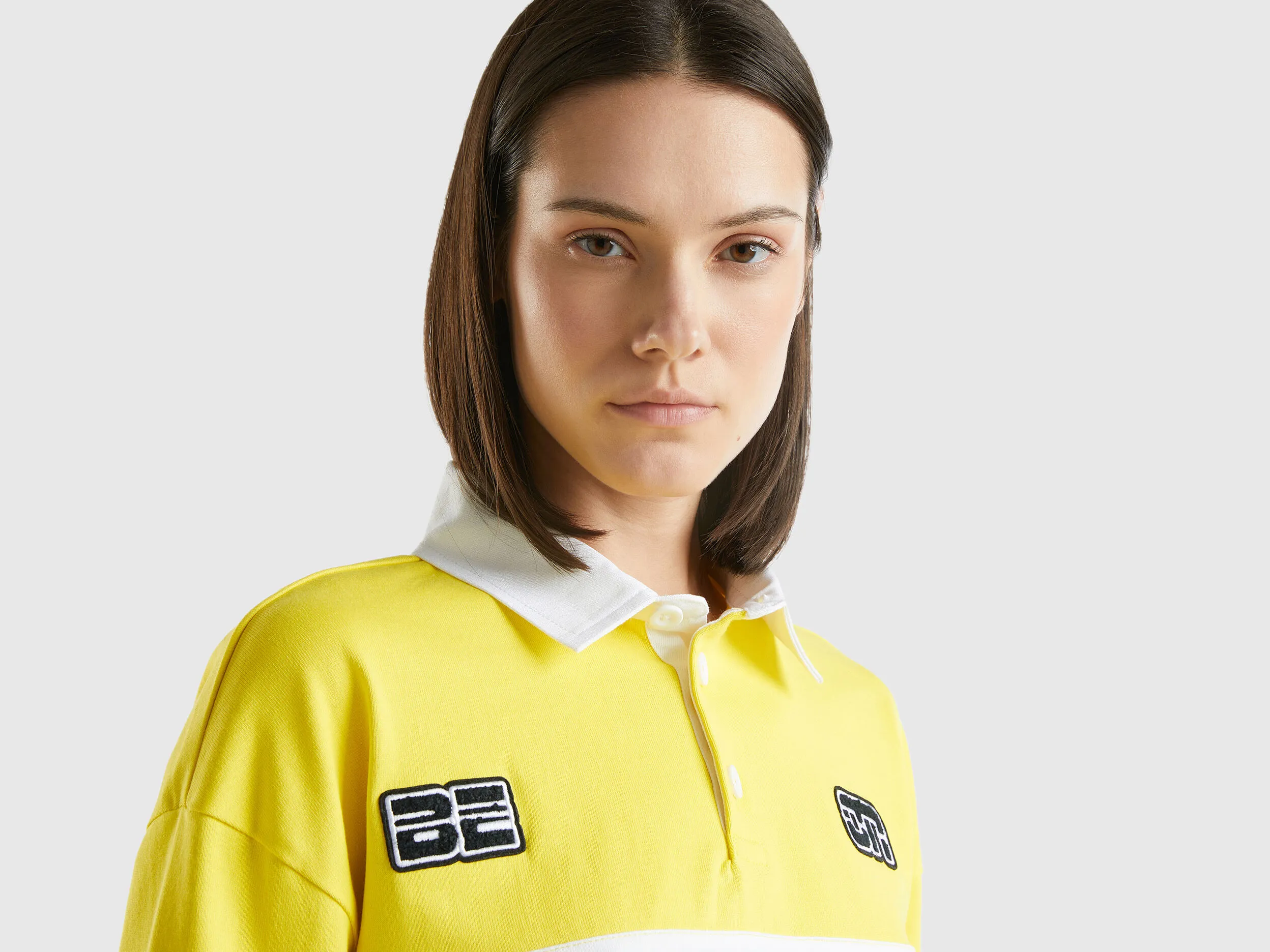Polo amarillo cropped con parche y estampados